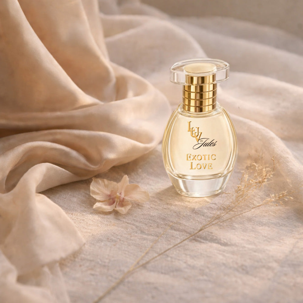 LUV by Jules Exotic Love perfume bottle surrounded by soft fabrics and flowers.